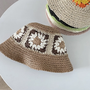Detail of handmade crochet straw hat with bohemian floral patterns and woven textures