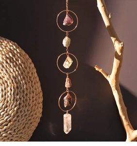 Detail of amethyst suncatcher with rose gold metal rings and natural crystal point