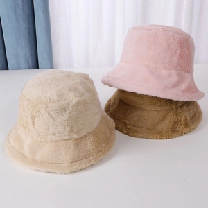 Detail of plush faux fur bucket hats in beige, pink and brown soft winter textures