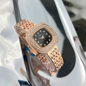 Detailed close-up of a rose gold square watch with a rhinestone bezel and black dial