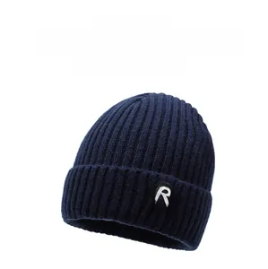 Detail of dark blue knit beanie featuring thick rib texture and a square R FASHION patch