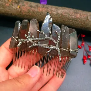Close-up of handmade smoky crystal hair comb with silver branch and gothic aesthetic