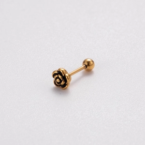 Close-up of a golden flower cartilage stud earring with black outline and screw back design