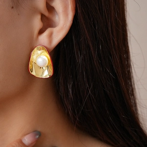 Vue détaillée de boucles d'oreilles vintage en or avec perle portées par un mannequin