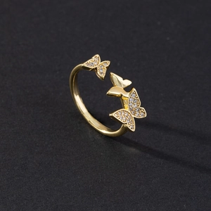 Detail of adjustable gold ring featuring three butterflies with micro-pave cubic zirconia
