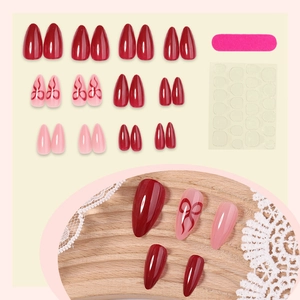 French almond press-on nails with red bows and solid colors including glue and file