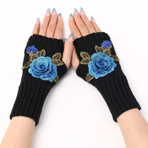 Detailed view of black knitted fingerless gloves featuring blue rose flower embroidery