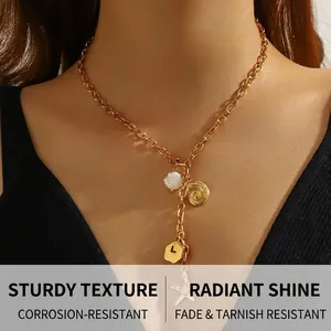 Detailed close-up of gold chain necklace with starfish, shell, and sea snail pendants
