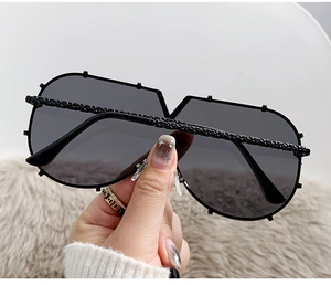 Detail view of fashion oversized shield sunglasses with woven texture metal temples