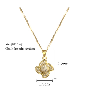Detail view of a gold clover necklace with dimensions 1.5x2.2cm and weight 3.4g on white background