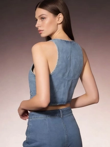 Close-up of a light blue denim vest with a slim fit cut and sleeveless cropped design