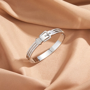 Detailed close-up of a silver-toned belt buckle bracelet with pavé-set cubic zirconia
