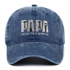 Detailed grey embroidery of tool patterns and PAPA text on washed blue cotton baseball cap