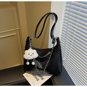 Detail of woven black shoulder bag with silver chain and cute cloud plush charm