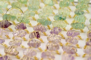Rows of handmade wire-wrapped rings with natural amethyst and green fluorite crystals