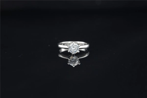 Macro view of a classic six-prong moissanite ring with a silver-tone polished metal finish