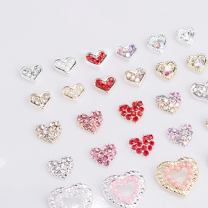 Detailed view of heart-shaped nail art charms with crystal rhinestones and pearls