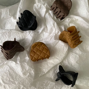 Detail view of small 4cm matte hair claws with quilted pattern texture in multiple colors