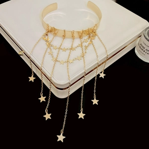 Detalle de una gargantilla chapada en oro con colgantes de estrellas y borlas en capas