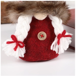 Macro detail of Christmas gnome ornament with red felt body and brown faux fur hat