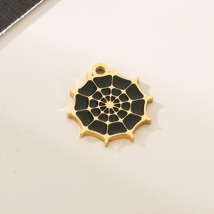 Macro detail of golden spider web pendant with black enamel fill and hanging loop