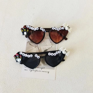 Kids heart-shaped Halloween sunglasses with Trick or Treat letters in black and brown