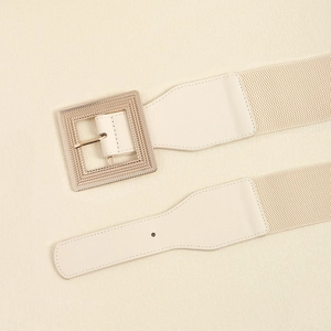 Close-up of beige elastic belt with PU leather ends and a square metal buckle detail