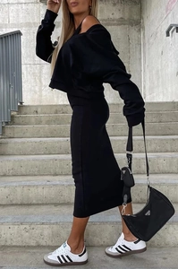 Λεπτομέρεια street style από μαύρο σετ κοντό φούτερ και μίντι φούστα στις σκάλες