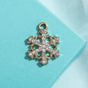 Detailed close-up of a gold snowflake pendant with sparkling white cubic zirconia stones