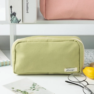 Close-up of light green canvas pencil case with zipper and stylish logo label