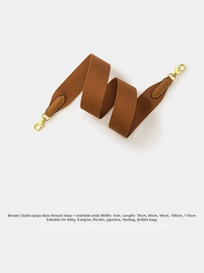 Close-up of 5cm wide brown woven guitar strap with leather ends and gold metal clips