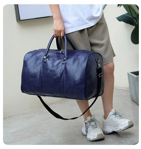 Bolso de viaje de cuero PU azul llevado por modelo mostrando gran capacidad y correa
