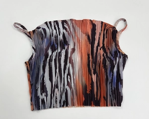 Detail of colorful printed pleated camisole featuring thin straps and vertical texture