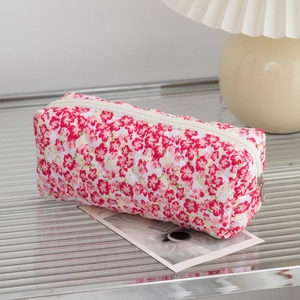 Detail view of floral quilted makeup bag with diamond texture and white zipper