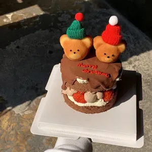 Christmas cake with teddy bear toppers wearing knit hats and Merry Christmas topper