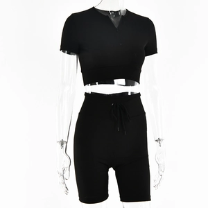 Detail of black ribbed knit two-piece set featuring a cropped zip-up top and drawstring shorts