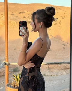 Detail of black floral burnt-out fabric on a slim-fit dress against desert backdrop