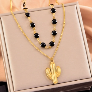 Collier double rang doré avec pendentif cactus et perles noires sur fond de soie