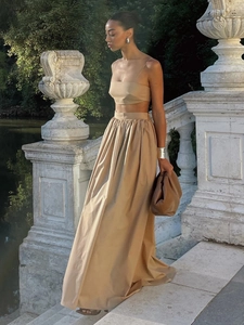 Tenue deux pièces en coton kaki avec crop top et jupe longue sur des marches en pierre