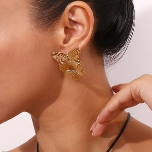 Close-up of 18K gold plated stainless steel butterfly earrings on a female model
