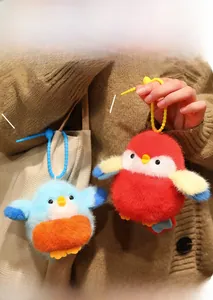 Détail de porte-clés oiseaux en peluche rouge et bleu avec texture douce et cordons