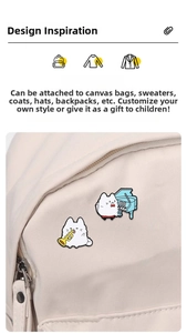 Detailed view of white cat enamel pins with trumpet and piano on a canvas bag
