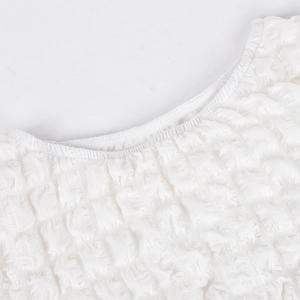 Detailed macro shot of white seersucker fabric texture and elastic off-shoulder neckline