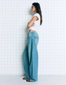 Side view of high-waisted wide-leg jeans in mid-blue wash with a loose vintage silhouette