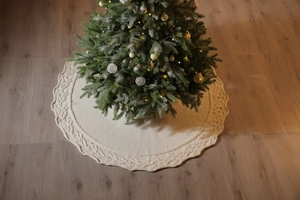 Detailed cable knit Christmas tree skirt in cream white with decorative wavy edges