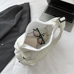 White puffy cloud crossbody bag showing large internal capacity for daily essentials
