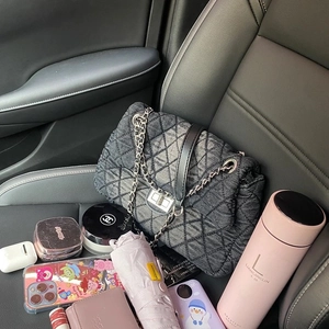 Quilted denim hobo bag with silver chain strap shown in car with daily essentials