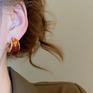 Detailed view of vintage amber resin C-shape earring with 18k gold plated silver needle