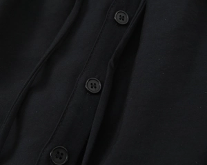 Macro view of black twill fabric detail with matching four-hole resin buttons