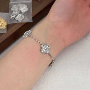 Silver clover leaf bracelet on wrist with elegant beaded edge and metallic finish